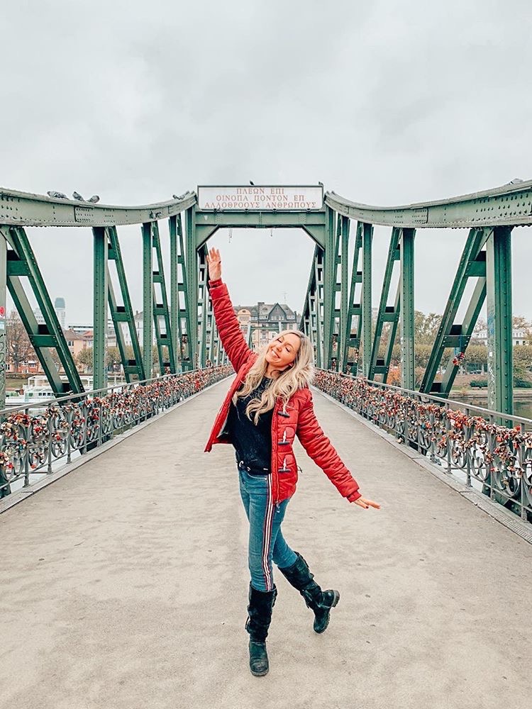 Smiling woman on Eiserner Steg in Frankfurt am Main, Germany. Photo by @marcelamoy